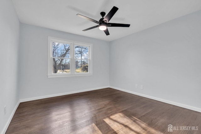 empty room with wood finished floors, a ceiling fan, and baseboards