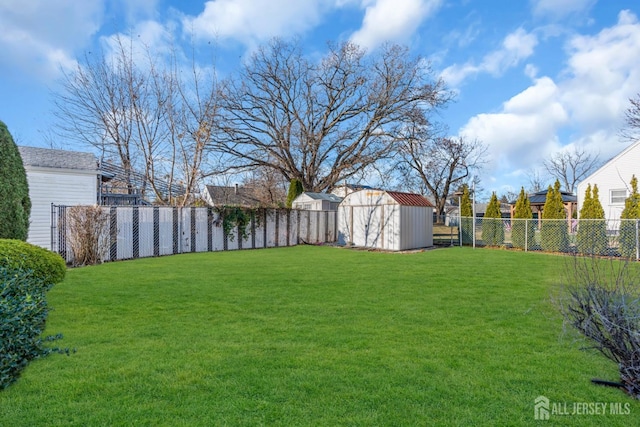 view of yard with a shed, a fenced backyard, and an outdoor structure