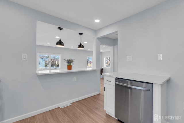 kitchen with visible vents, baseboards, light wood-style floors, white cabinets, and stainless steel dishwasher