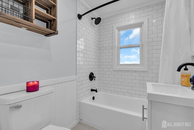 full bath with shower / bath combo, wainscoting, vanity, and toilet