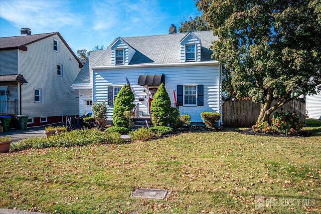 cape cod home featuring a front yard