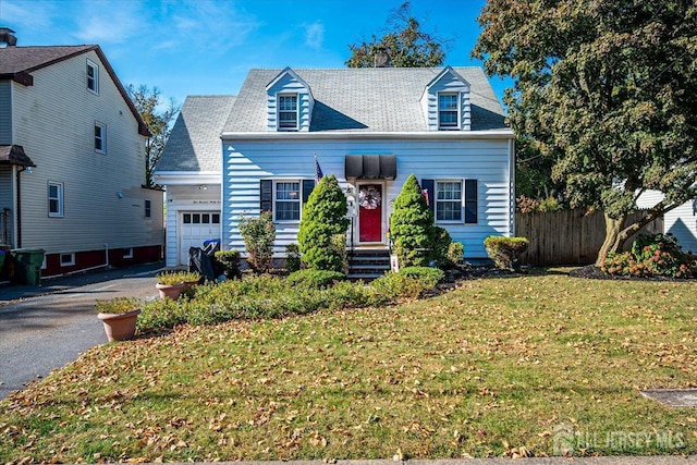 cape cod home with a front yard and a garage