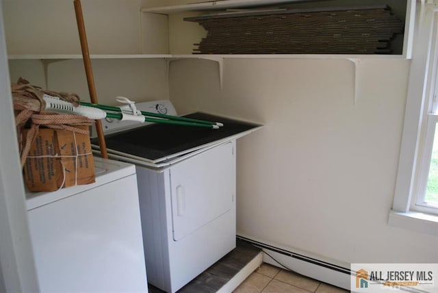 laundry room with laundry area, a baseboard heating unit, light tile patterned flooring, and separate washer and dryer