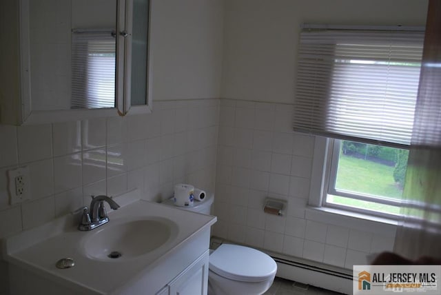 bathroom featuring vanity, toilet, tile walls, and a baseboard radiator