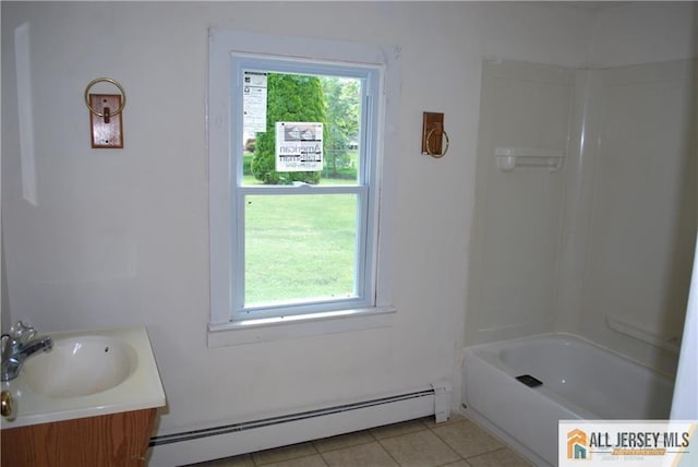 full bath with vanity, tile patterned flooring, baseboard heating, and washtub / shower combination