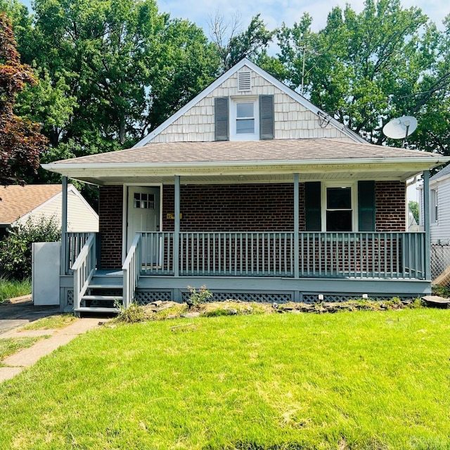 bungalow with covered porch and a front yard