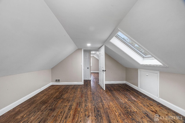 bonus room with vaulted ceiling and dark wood-type flooring