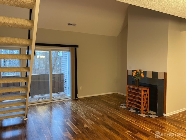 unfurnished living room featuring lofted ceiling and dark wood-type flooring