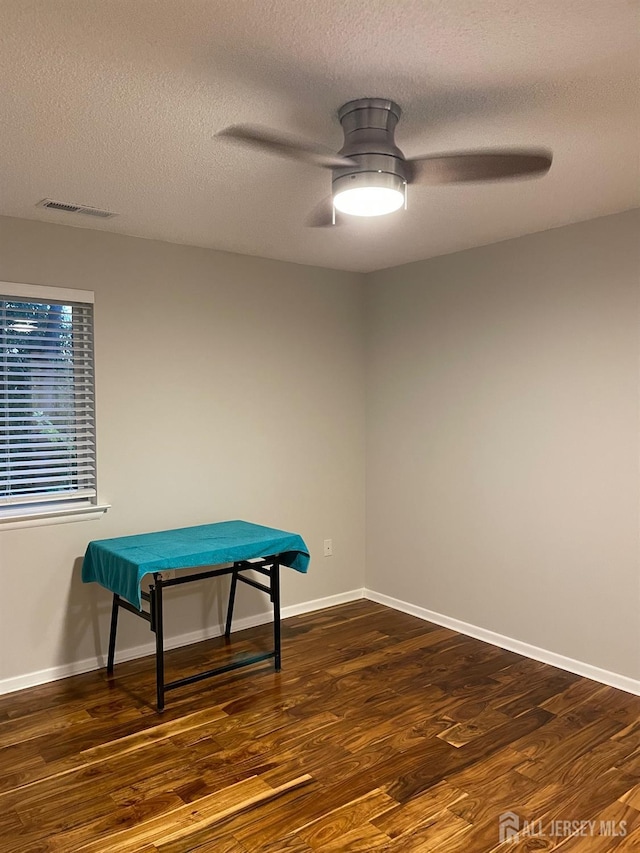 playroom with ceiling fan, a textured ceiling, and dark hardwood / wood-style flooring