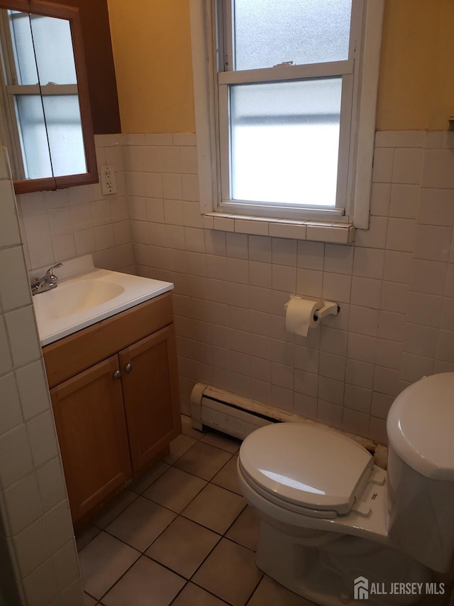 half bathroom with tile patterned floors, toilet, and tile walls