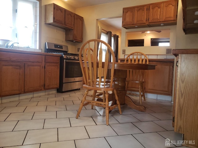 kitchen with a sink, stainless steel range with gas stovetop, and brown cabinetry