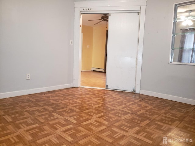 empty room with baseboard heating, baseboards, and a ceiling fan