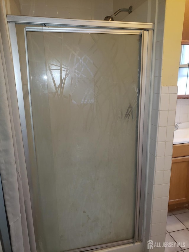 full bathroom with tile patterned flooring, vanity, and a stall shower