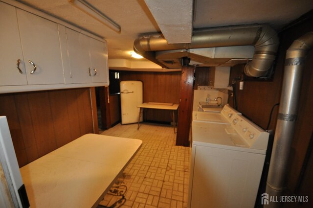 19 Clark Pl, Avenel, NJ 07001 - finished basement featuring wooden walls, washing machine and clothes dryer, and brick patterned flooring