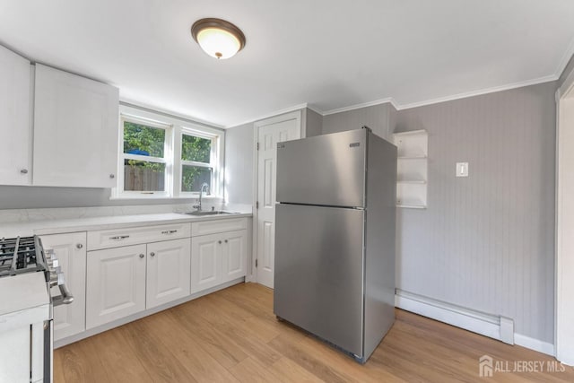 kitchen with light hardwood / wood-style floors, white cabinetry, baseboard heating, sink, and stainless steel appliances