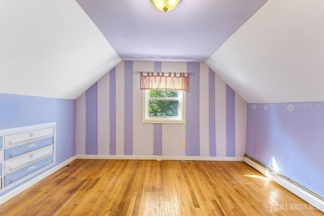 additional living space featuring wood-type flooring, baseboard heating, and lofted ceiling