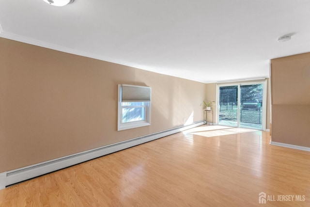 spare room featuring light hardwood / wood-style floors and a baseboard heating unit