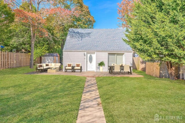 rear view of property featuring a patio area, a lawn, outdoor lounge area, and a shed