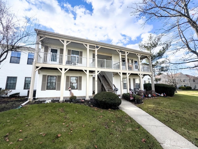 view of front facade with a balcony and a front lawn