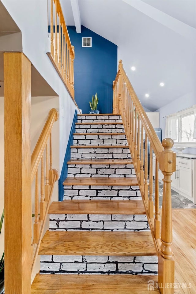 stairs featuring wood finished floors and recessed lighting