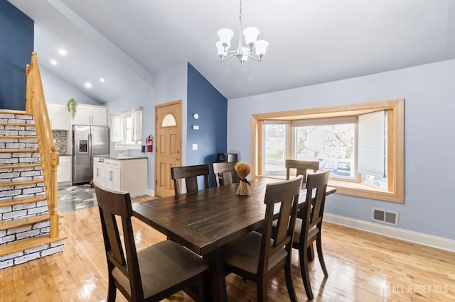 dining room with lofted ceiling, a chandelier, stairs, light wood-style flooring, and baseboards