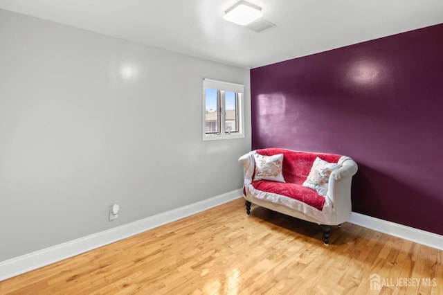 living area with baseboards and wood finished floors