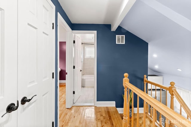 hall with wood finished floors, an upstairs landing, baseboards, and recessed lighting