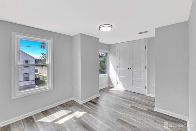 unfurnished room featuring baseboards and light wood-type flooring