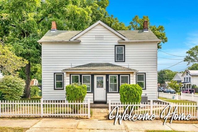 33 Stockton Ave, Jamesburg, NJ 08831 - traditional-style house featuring a chimney, a fenced front yard, a shingled roof, and central AC unit