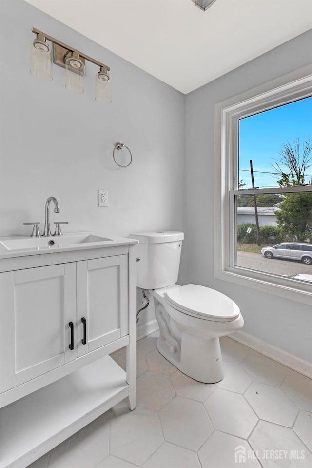 bathroom featuring baseboards, toilet, vanity, and tile patterned floors