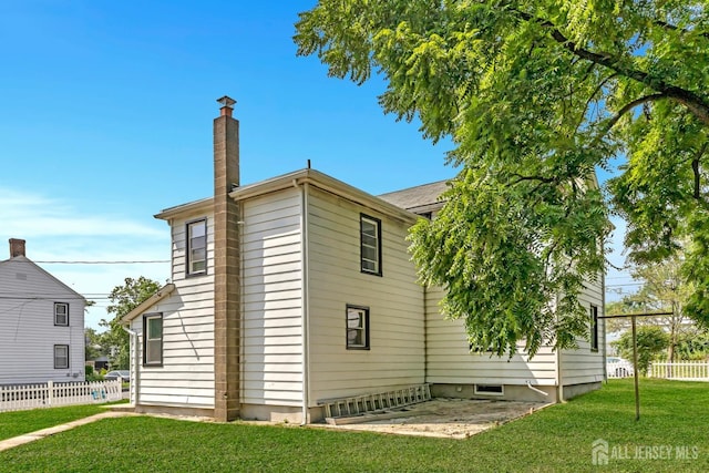 rear view of house with a chimney and a patio