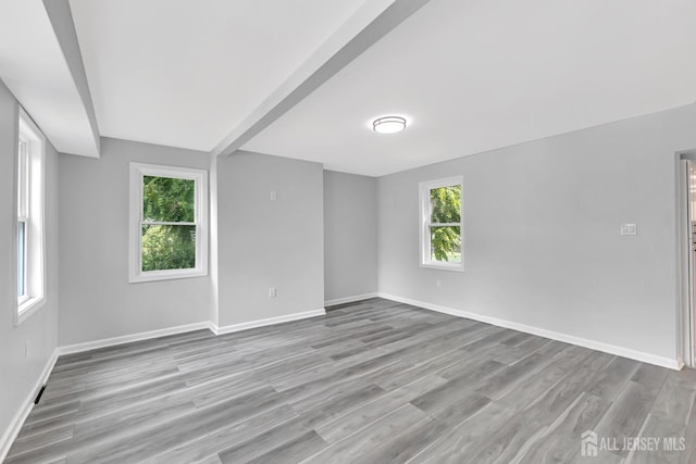 spare room featuring baseboards and wood finished floors