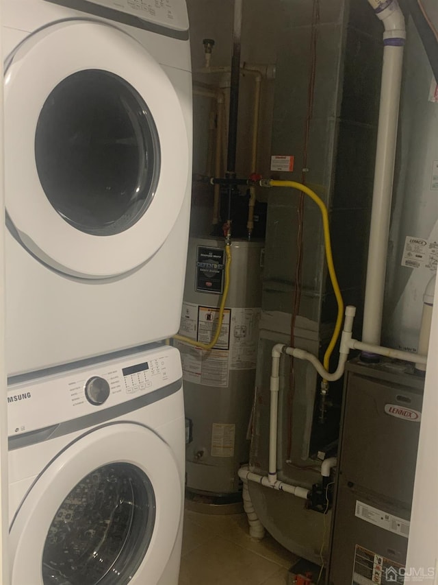 1156 Morning Glory Dr, Monroe, NJ 08831 - laundry room featuring stacked washer / dryer, water heater, and tile patterned flooring