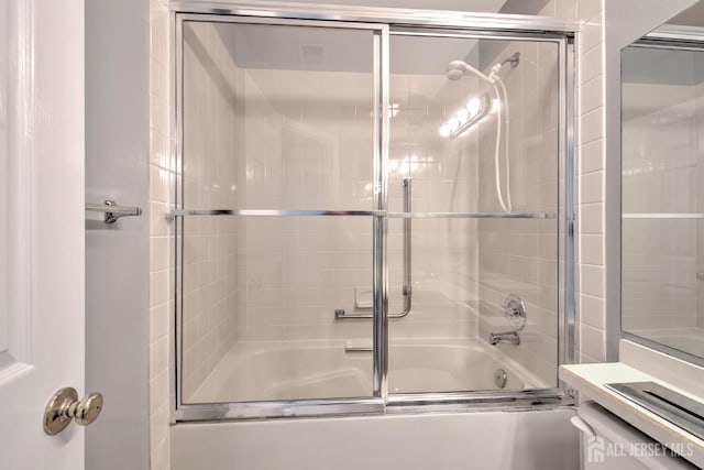 full bathroom with shower / bath combination with glass door and vanity