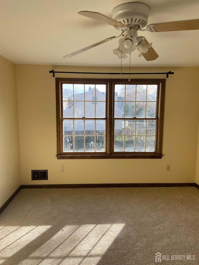 spare room with ceiling fan and carpet