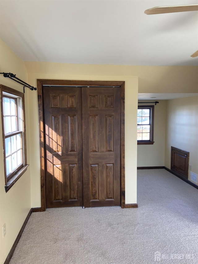 unfurnished bedroom with light carpet and ceiling fan