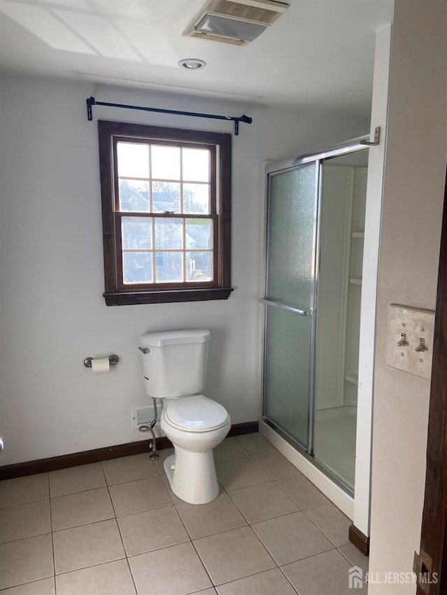 bathroom with a shower with door, tile patterned floors, and toilet