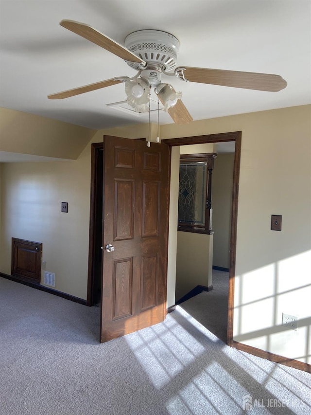 unfurnished room with dark colored carpet and ceiling fan