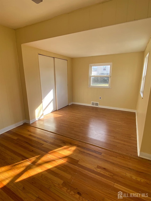 unfurnished bedroom featuring hardwood / wood-style flooring and a closet