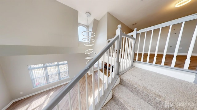 stairway featuring plenty of natural light, a high ceiling, and baseboards