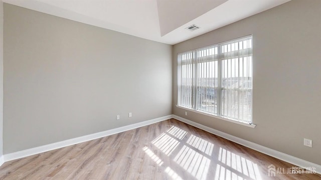 unfurnished room with visible vents, baseboards, and wood finished floors