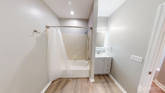 bathroom featuring shower / bath combo with shower curtain, vanity, baseboards, and wood finished floors