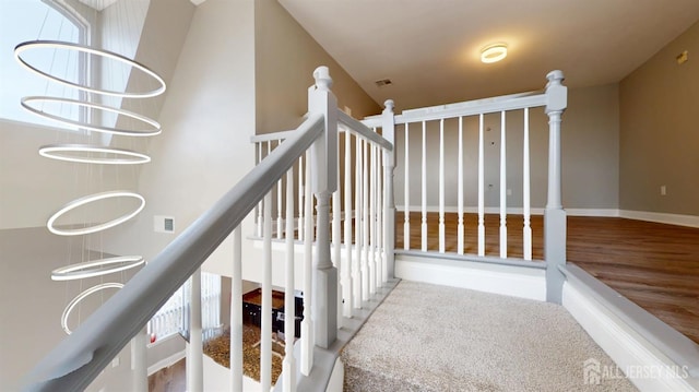 staircase featuring visible vents, baseboards, and a towering ceiling