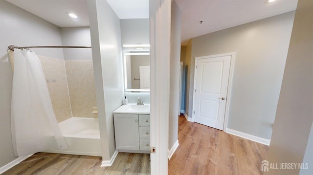 full bathroom featuring shower / bathtub combination with curtain, baseboards, wood finished floors, and vanity