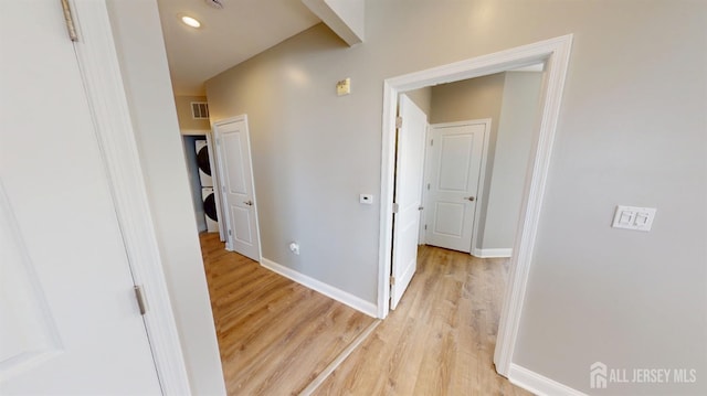 hallway featuring visible vents, light wood-type flooring, and baseboards