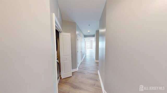 hall with baseboards and light wood-type flooring