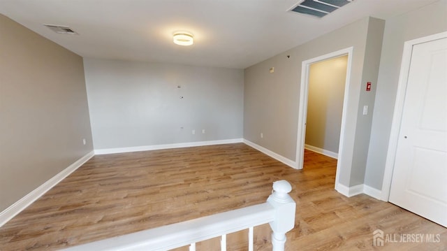 unfurnished room with light wood-style flooring, baseboards, and visible vents