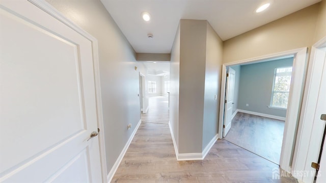 hall with light wood finished floors, recessed lighting, and baseboards