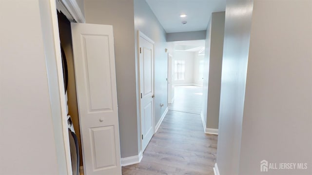 hallway featuring baseboards and light wood finished floors