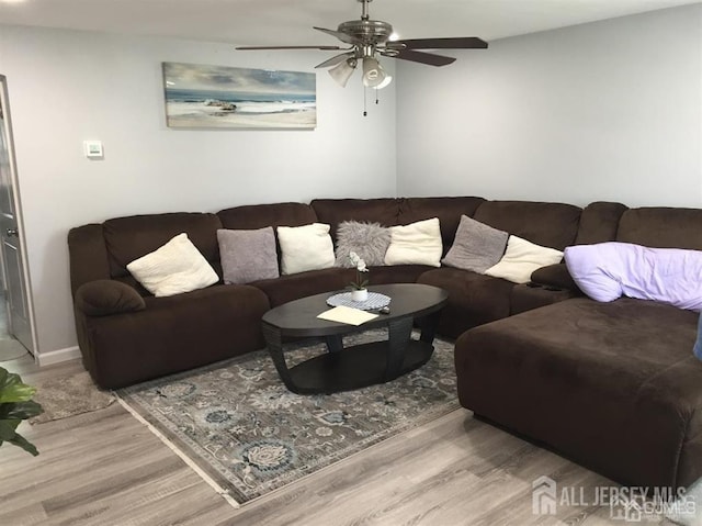 living room featuring ceiling fan and light hardwood / wood-style floors